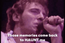 a man singing into a microphone with the words " those memories come back to haunt me " below him