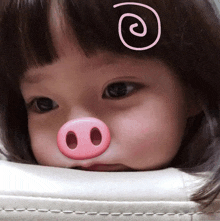 a little girl with a pig nose and a swirl on her forehead