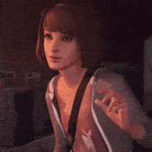 a woman in a hoodie is waving her hand in a dark room .