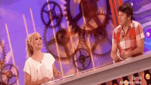 a man and a woman are sitting at a table in front of gears ..