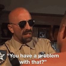a man in a sheriff 's uniform talks to another man with the words " you have a problem with that "
