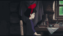 a girl with a red bow on her head sits in front of a window