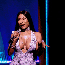 a woman in a money print dress is singing into a microphone ..