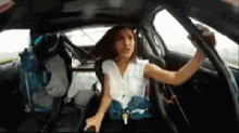 a girl in a white shirt is sitting in a car