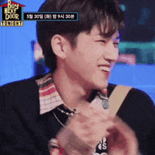a young man is smiling in front of a sign that says ' boy next door tonight '