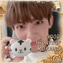 a picture of a boy holding a stuffed animal with the words good hyunyeop morning written on it
