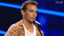 a man singing into a microphone with the word talent on the bottom right