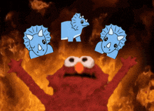 elmo stands in front of a fire with three blue dinosaurs