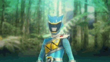 a blue power ranger with a cat ear helmet is standing in the woods