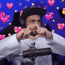 a man wearing headphones is making a heart shape with his hands