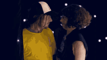 a man wearing a yellow shirt that says ' i love you ' on it looks at a woman