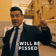 a man in a suit and tie says " i will be pissed " in front of a yellow building