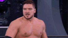 a shirtless man with a beard is standing in a wrestling ring