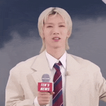 a man in a suit and tie is holding a microphone that says ten 's news on it