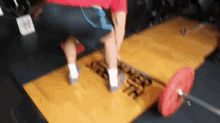 a person is standing on a yellow mat in a gym .
