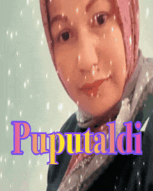 a woman wearing a pink head scarf stands in front of a sign that says puputtaldi
