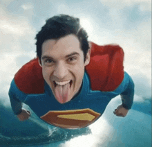 a man in a superman costume sticks his tongue out