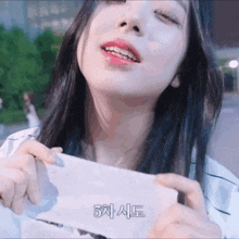 a close up of a woman holding a piece of paper that says 3
