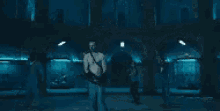 a man is standing in a dark room with his arms outstretched in a movie scene .