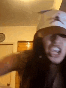 a woman wearing a baseball cap and sunglasses is making a funny face .
