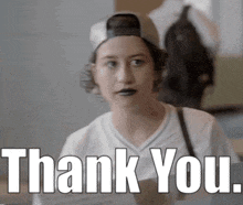 a girl wearing a baseball cap and a white shirt says thank you