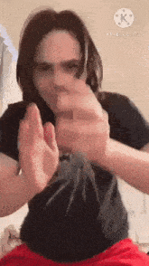 a man is holding a spider in his hands and making a stop sign .