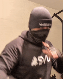 a man wearing a mask and a hoodie that says svu on it