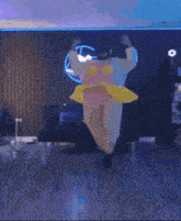 a person in a pink and yellow costume is dancing on a stage