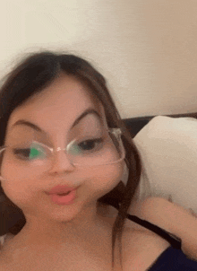 a girl wearing glasses is making a face