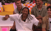 a group of men are sitting on a couch laughing and having fun .