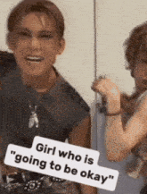 a girl who is going to be okay is standing next to another girl