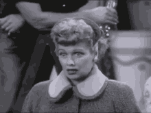 a black and white photo of a woman wearing a collared jacket