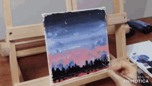 a painting of a city skyline is being painted on a wooden easel