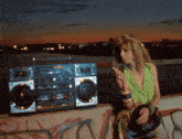 a woman smoking a cigarette next to a boombox that says ' pioneer ' on the front