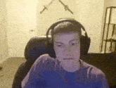 a young man wearing headphones is sitting in a chair in a room .