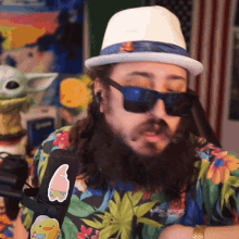 a man with a beard wearing sunglasses and a hat has a sticker on his shirt that says spongebob