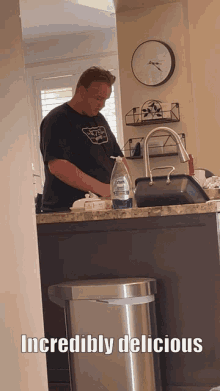 a man in a black shirt is standing in front of a kitchen sink with the words incredibly delicious written below him