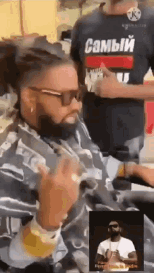a man with dreadlocks is getting his hair cut by a barber in a barber shop .