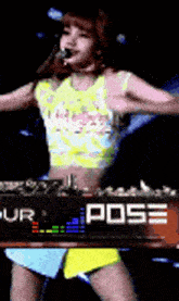 a woman is singing into a microphone while standing in front of a sign that says pose .