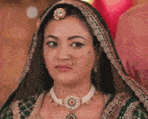 a woman with a nose ring is wearing a green dress