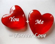 two red hearts with the words " you + me " written on them