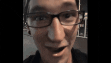a close up of a man wearing glasses and making a funny face .
