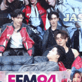 a group of people sitting in front of a sign that says femoa