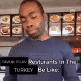 a man is standing in front of a menu in a restaurant and says " avuk pilav restuarants in the turkey be like "