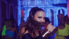 a woman with a ponytail is smiling in front of a crowd of people