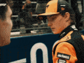 a man wearing an orange jacket with jack daniels on the sleeve