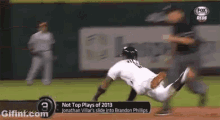 a baseball player is sliding into brandon phillips ' base