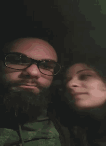a man and a woman are looking at each other in a dark room .