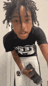 a young man with dreadlocks is wearing a black shirt that says " keep "