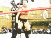 two men are wrestling in a ring with a crowd in the background